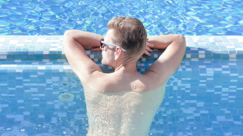 夏のプールで紫外線を浴びる男性