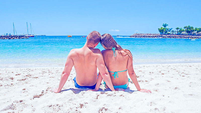 夏のビーチで紫外線を受けるカップル