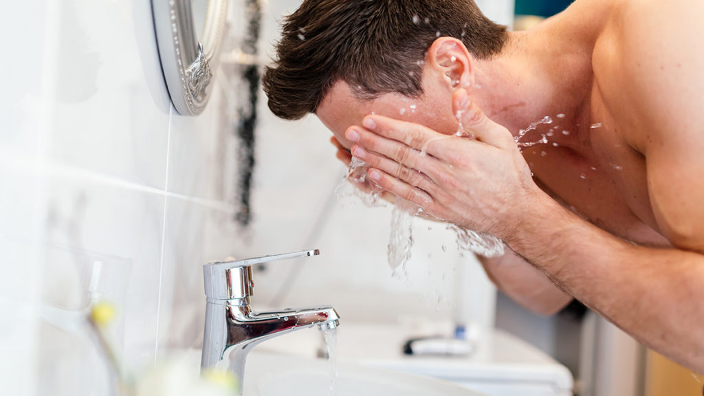 顔を洗う40代男性