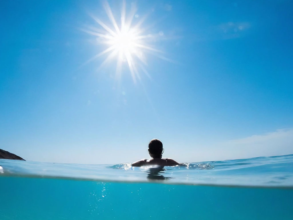 紫外線を浴びながら海に浸かる男性